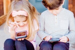 Two kids using smartphones